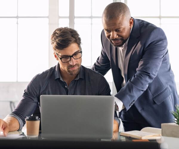 Two PEO employees looking at computer screen