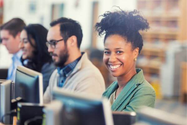 Employee smiling in front of computer