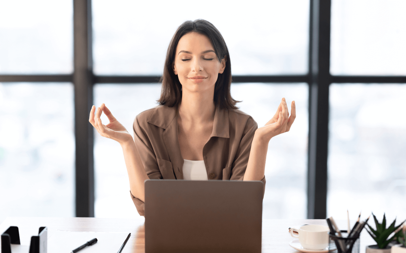 Woman meditating in front of computer