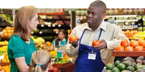 Grocery store worker holding tomatoes