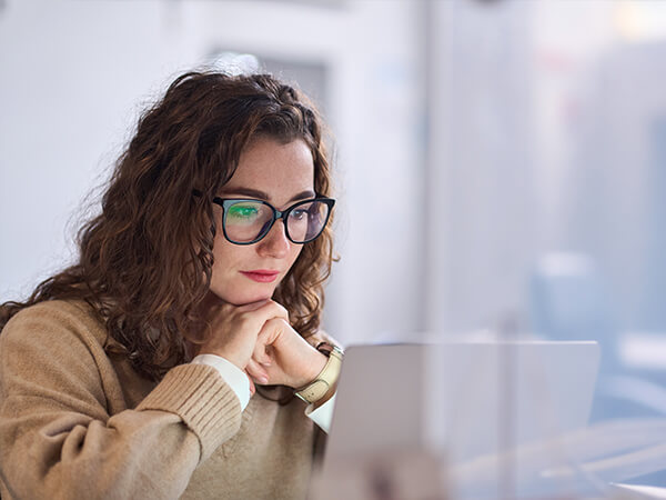Employee smiling in front of computer